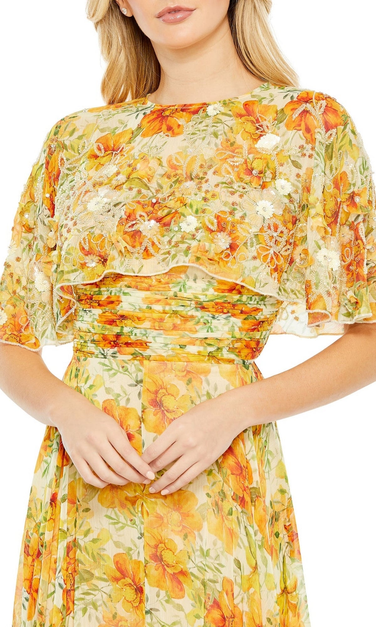 A woman wears the Long Formal Dress 9201 by Mac Duggal, featuring a yellow floral a-line silhouette with short flutter sleeves and a fitted waist, shown from shoulders to mid-thigh.